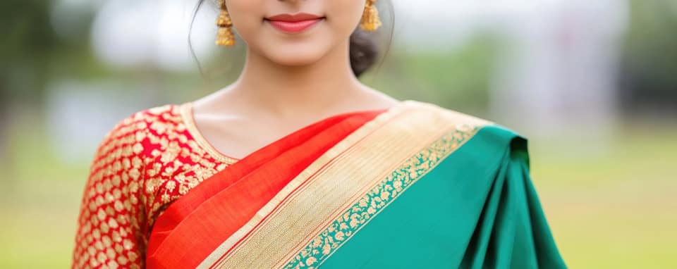 A woman wearing a green and red sari with gold detailing